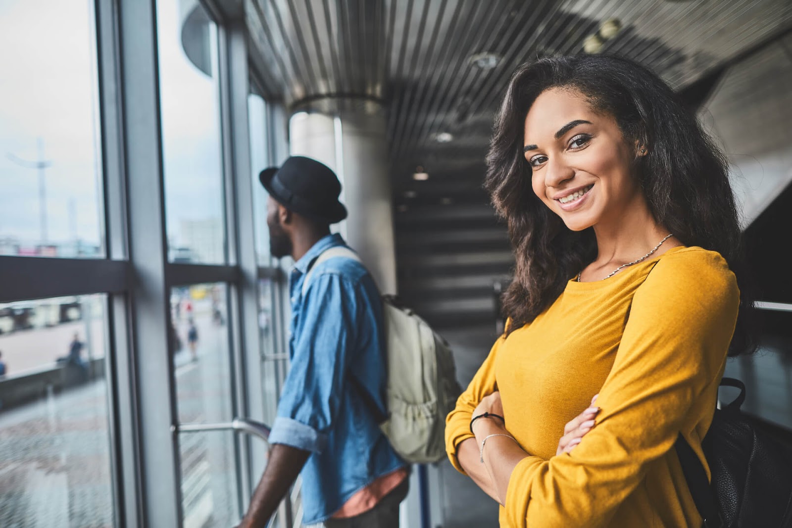 Man and woman waiting at the airport to use their travel rewards