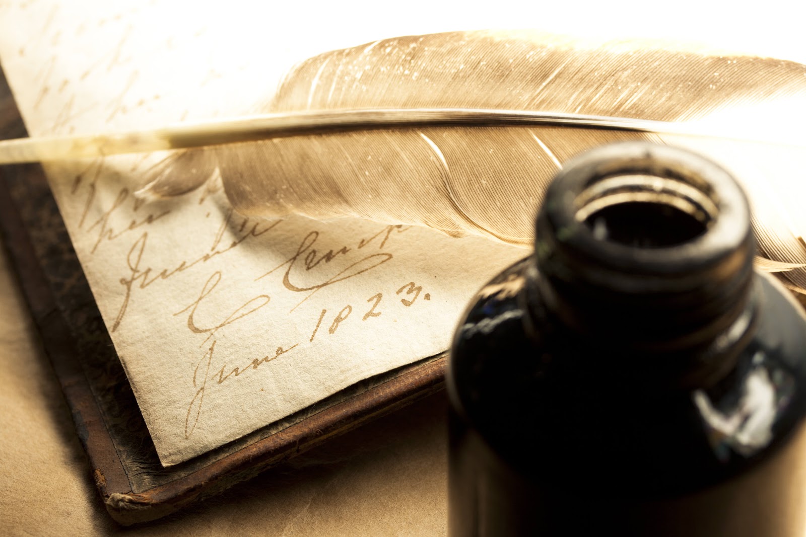 Feather quill and ink bottle with parchment