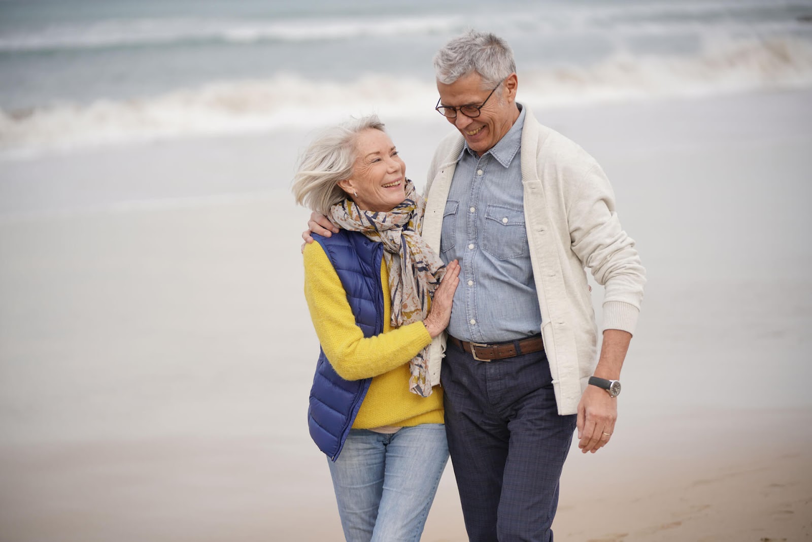 Man and wife walking down the beach together