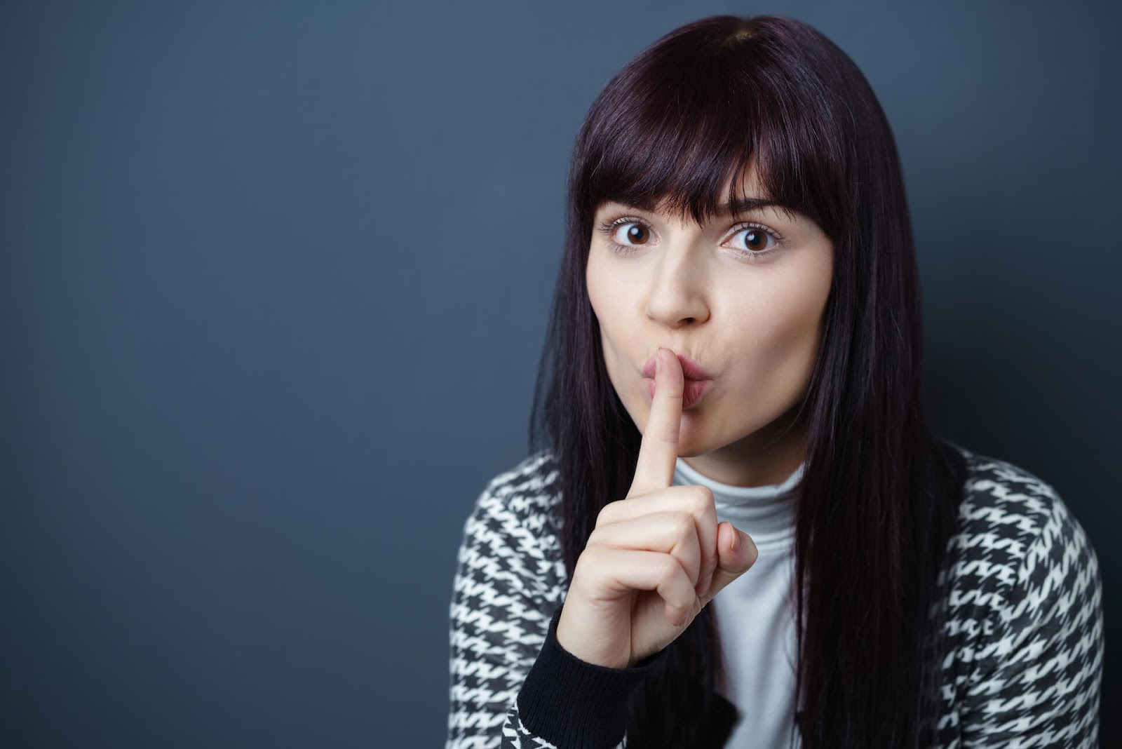 Woman holding her finger up to her mouth