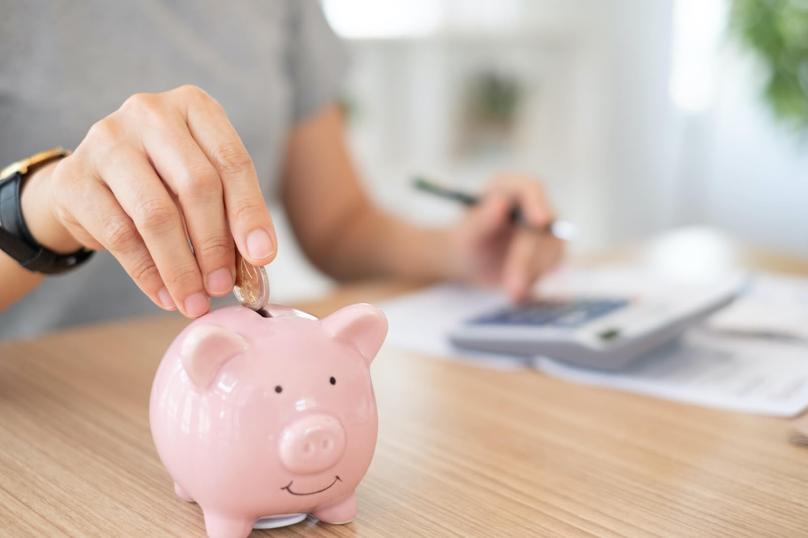 Man putting some change in a piggy bank