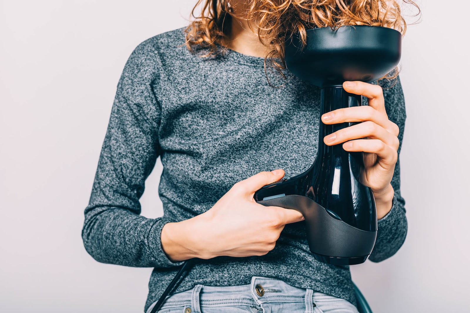 Woman blowdrying her curly hair with a diffuser