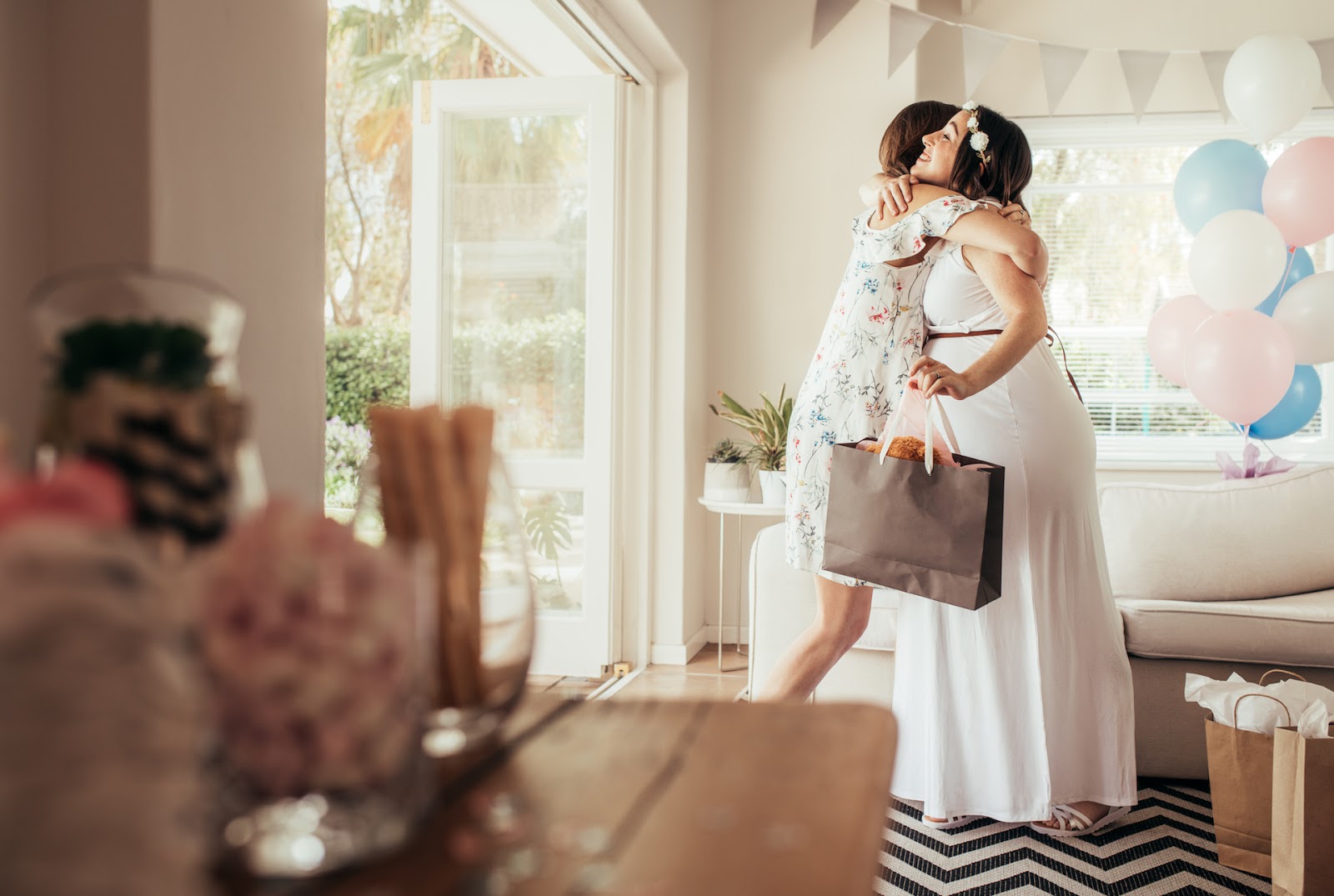 Woman hugging her pregnant friend at her baby shower