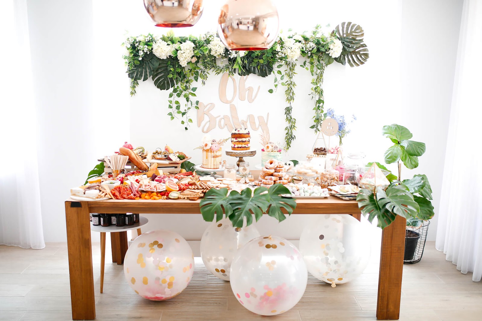 Baby shower food table with greenery around it