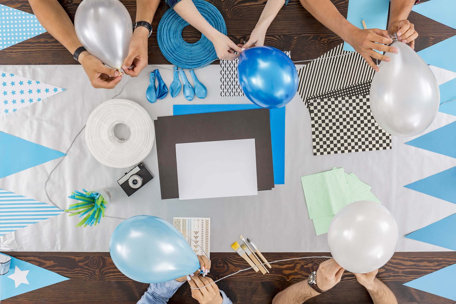 Hands blowing up and tying balloons together