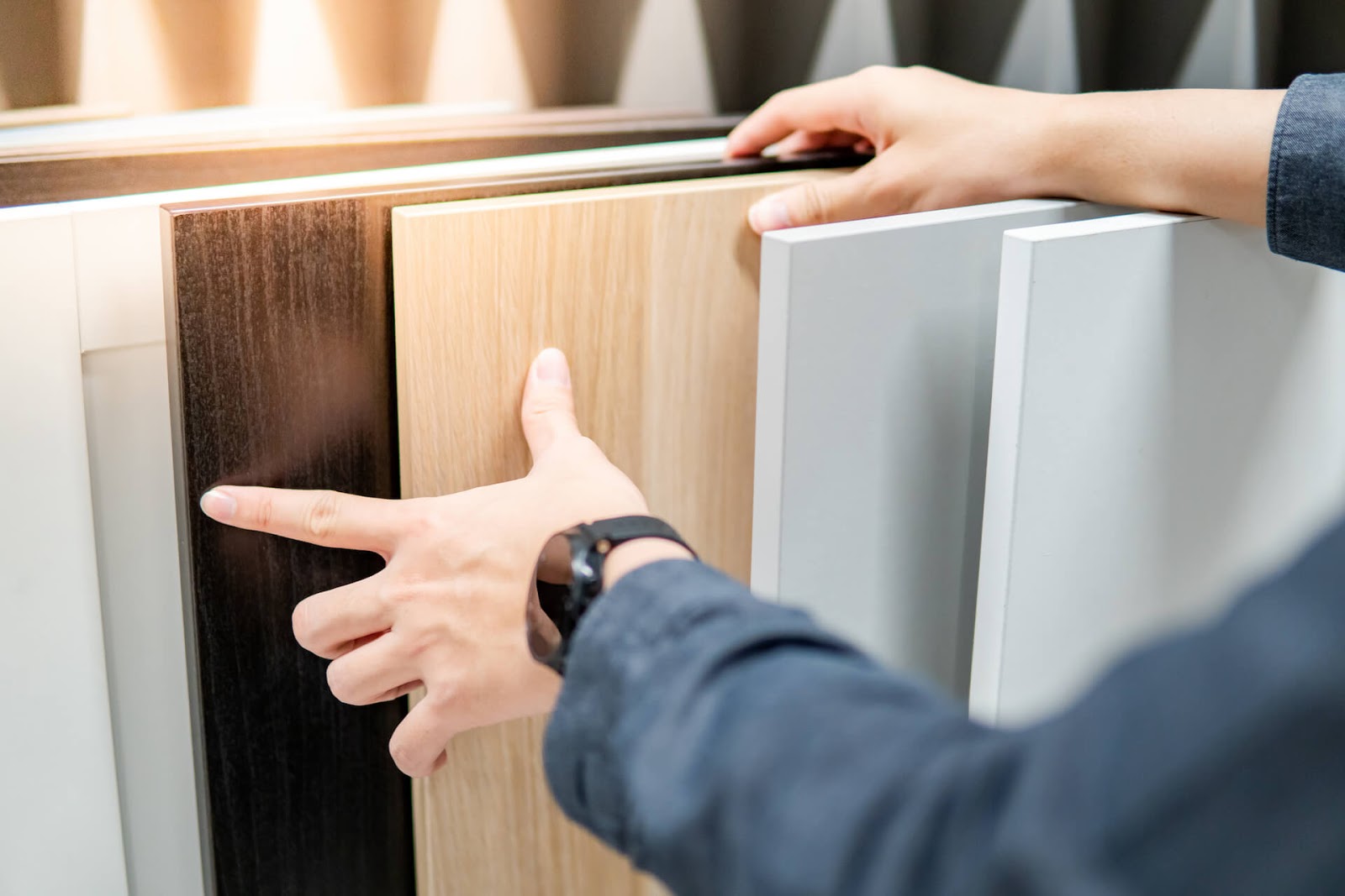 Close up of hand looking through cabinet samples