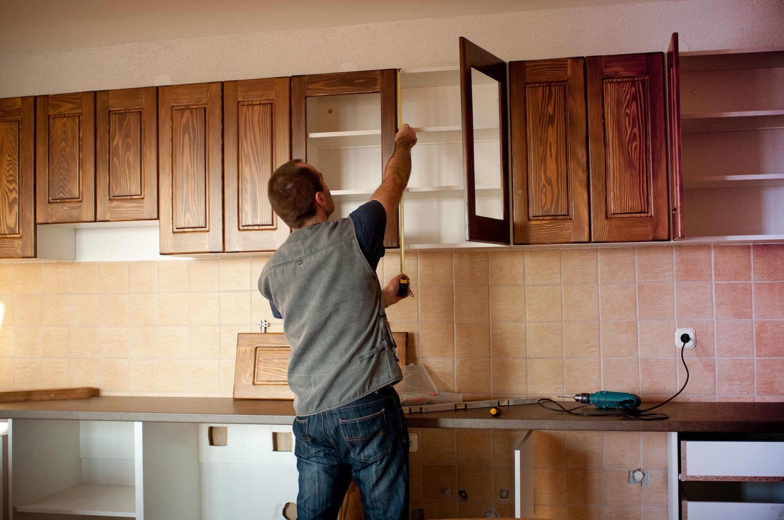 Man measuring cabinets