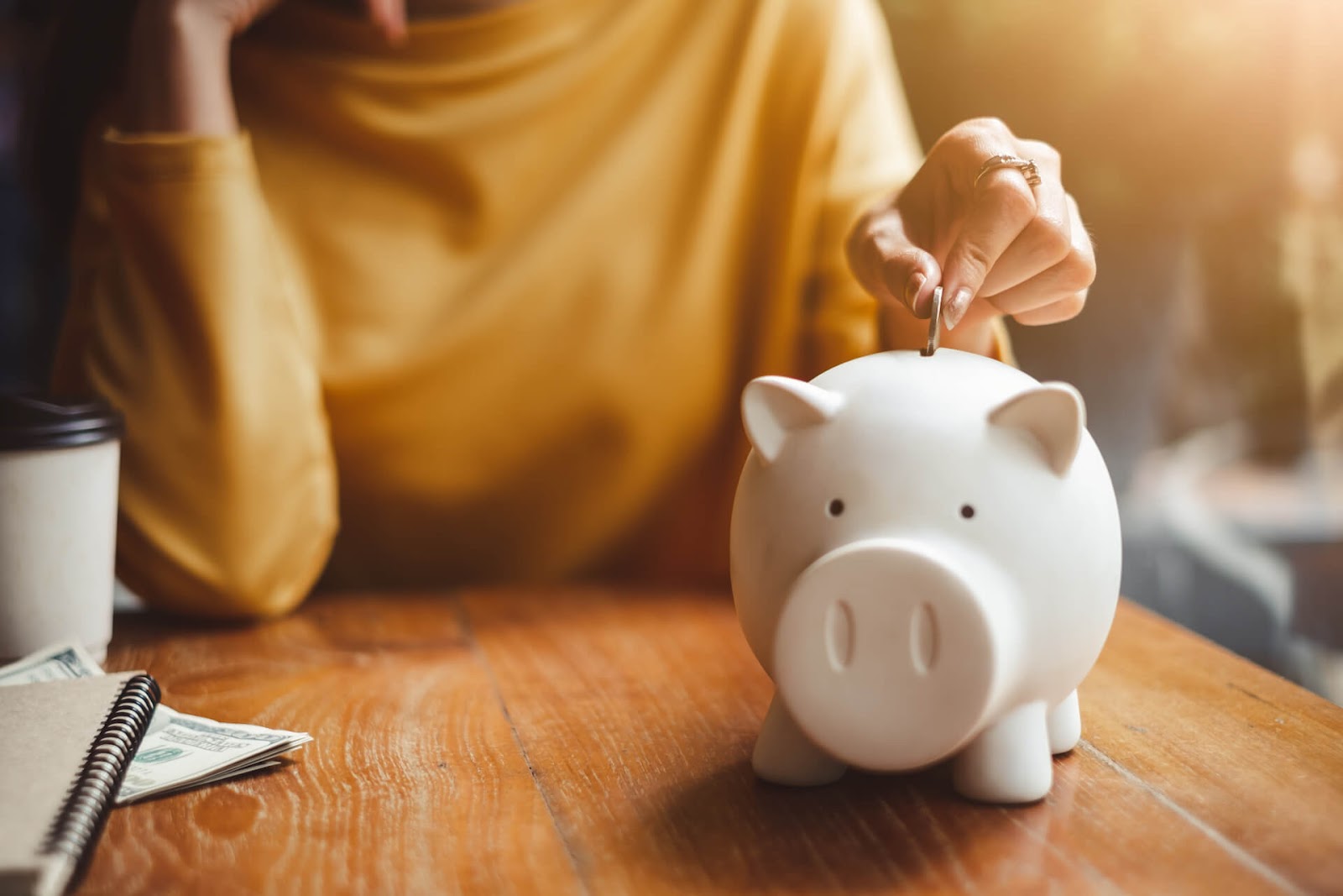 Woman putting change in a piggy bank