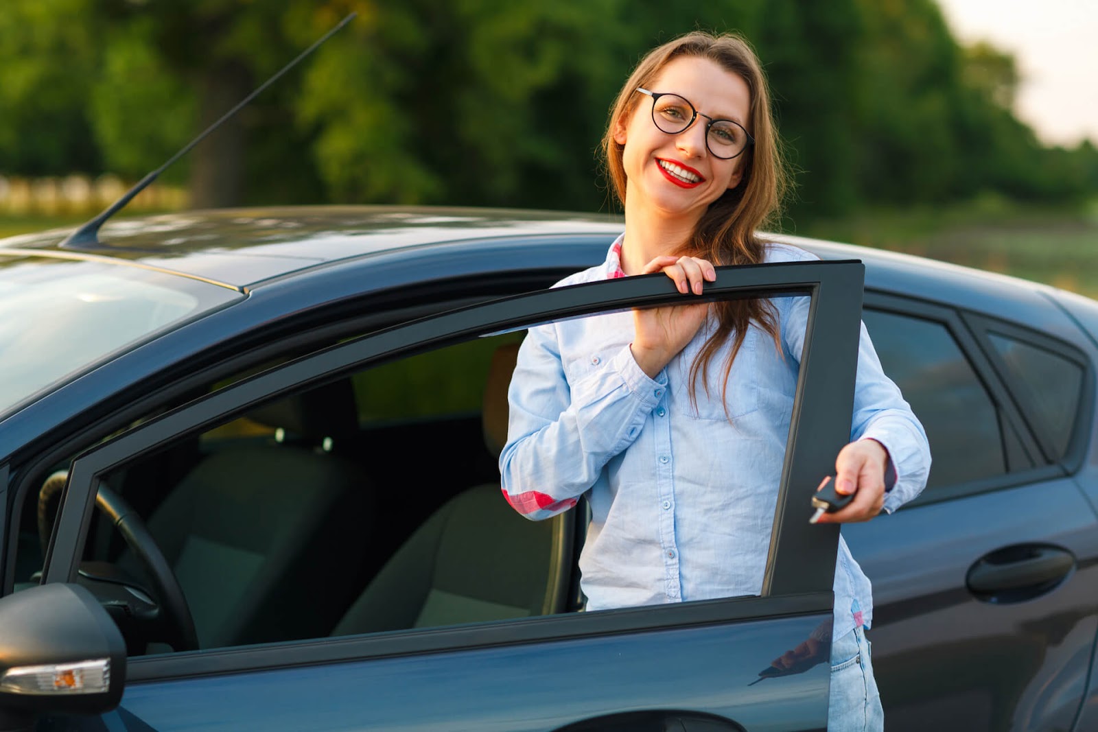 Woman smiling next to her new car