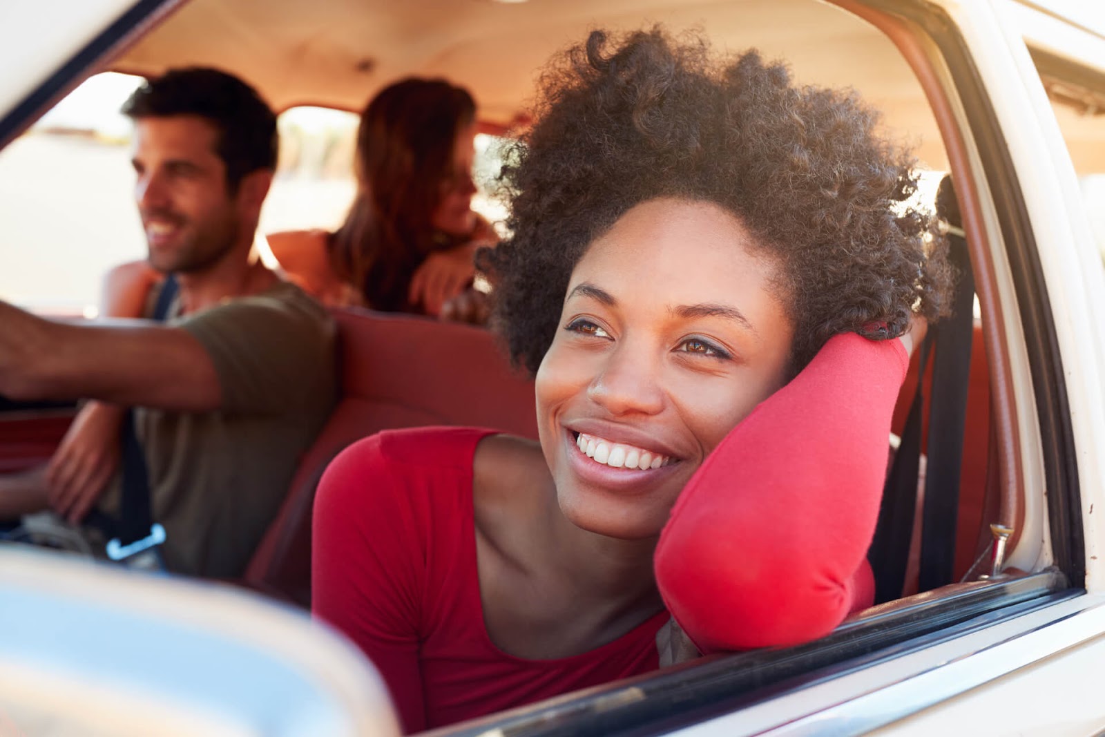 Woman enjoying a car ride with some friends