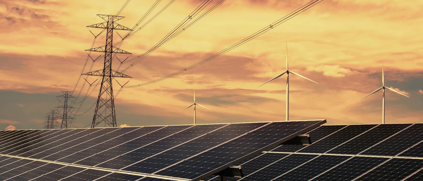 Sunset view of solar panels, electricity lines and windmills