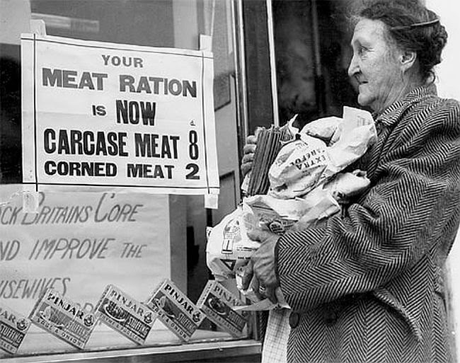 Woman looking at a new war ration sign while holding food