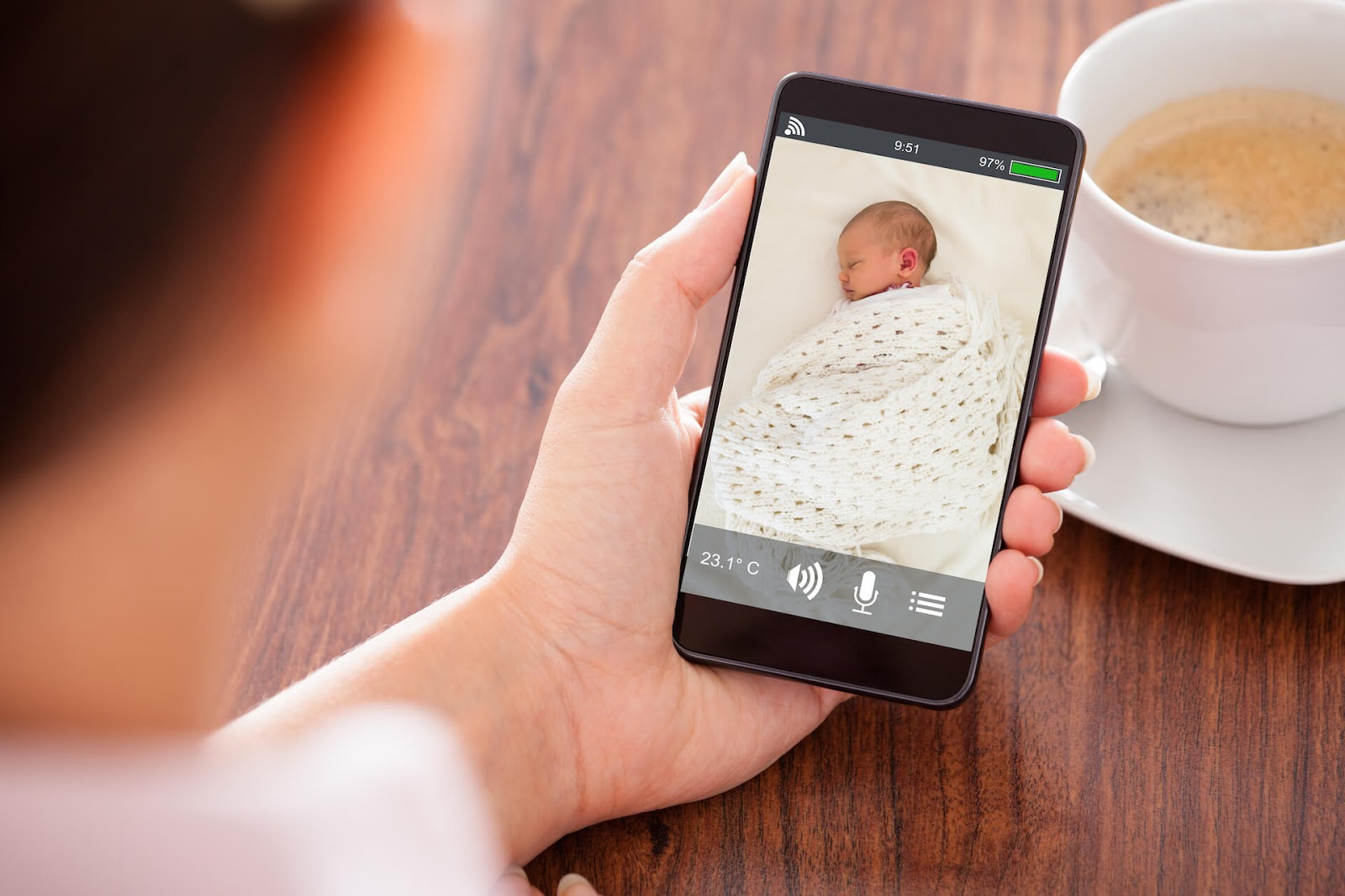 Woman watching her baby sleep on her smartphone
