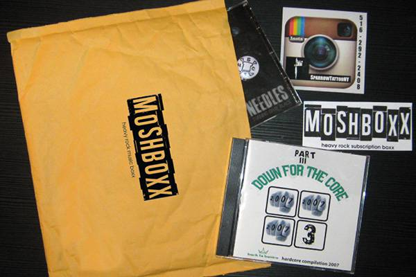 Contents of a MosBoxx subscription box including a cd, and some stickers