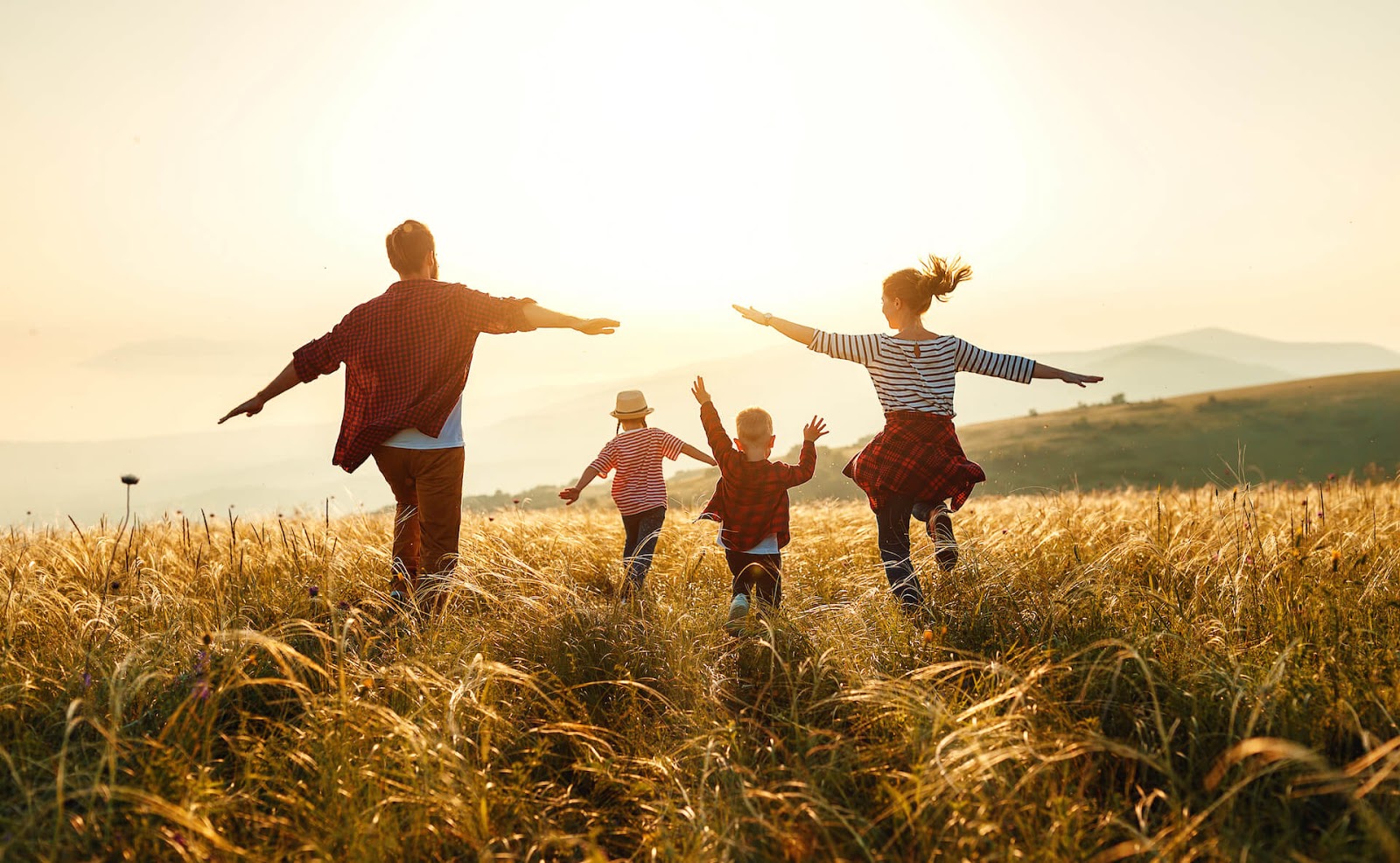 Family frolicking through a field together