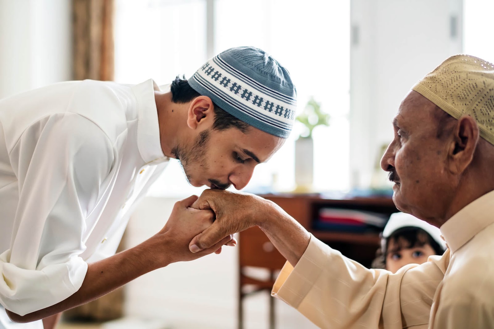 Younger man kissing the hand of his teacher