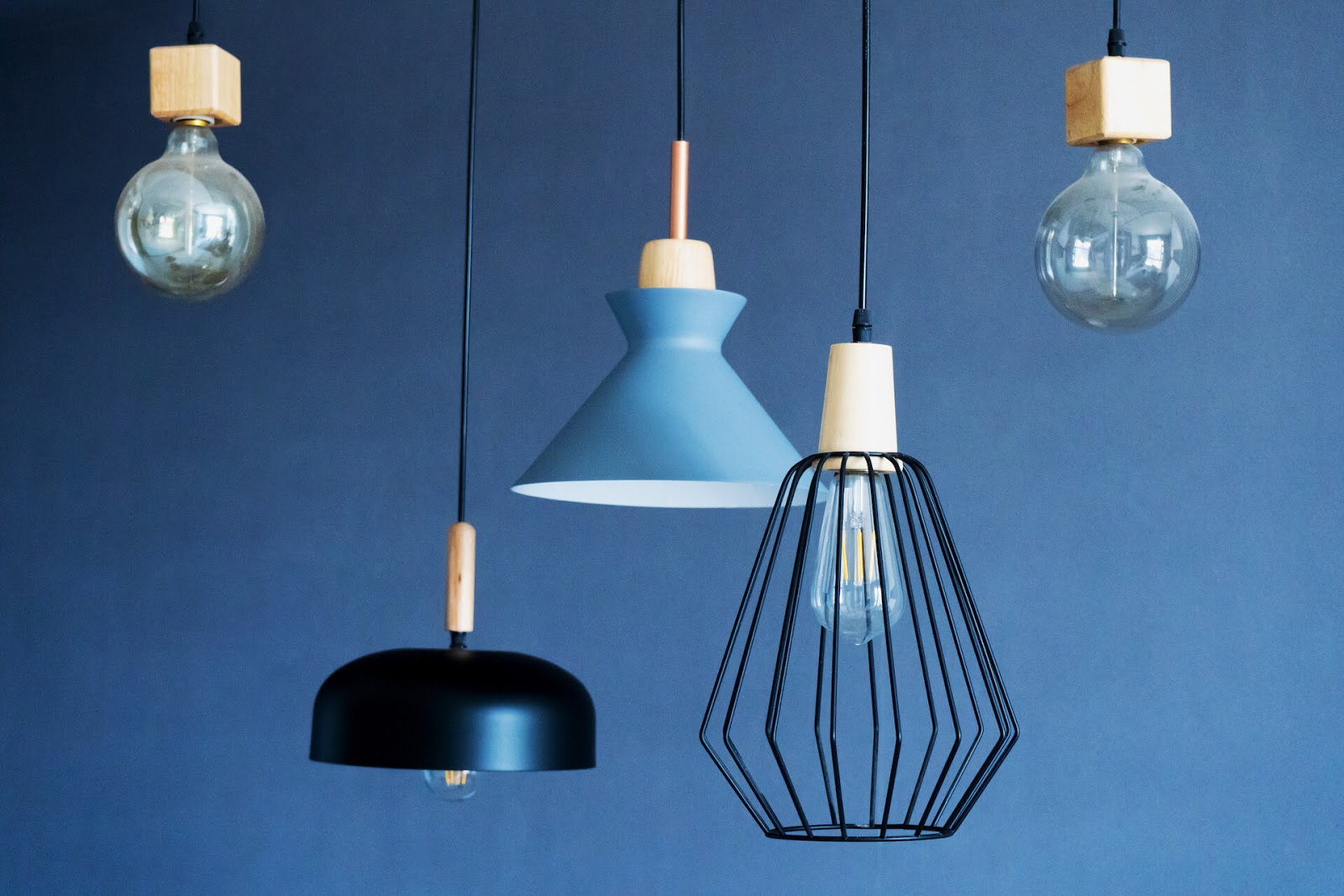 Different hanging ceiling lights against a blue backdrop