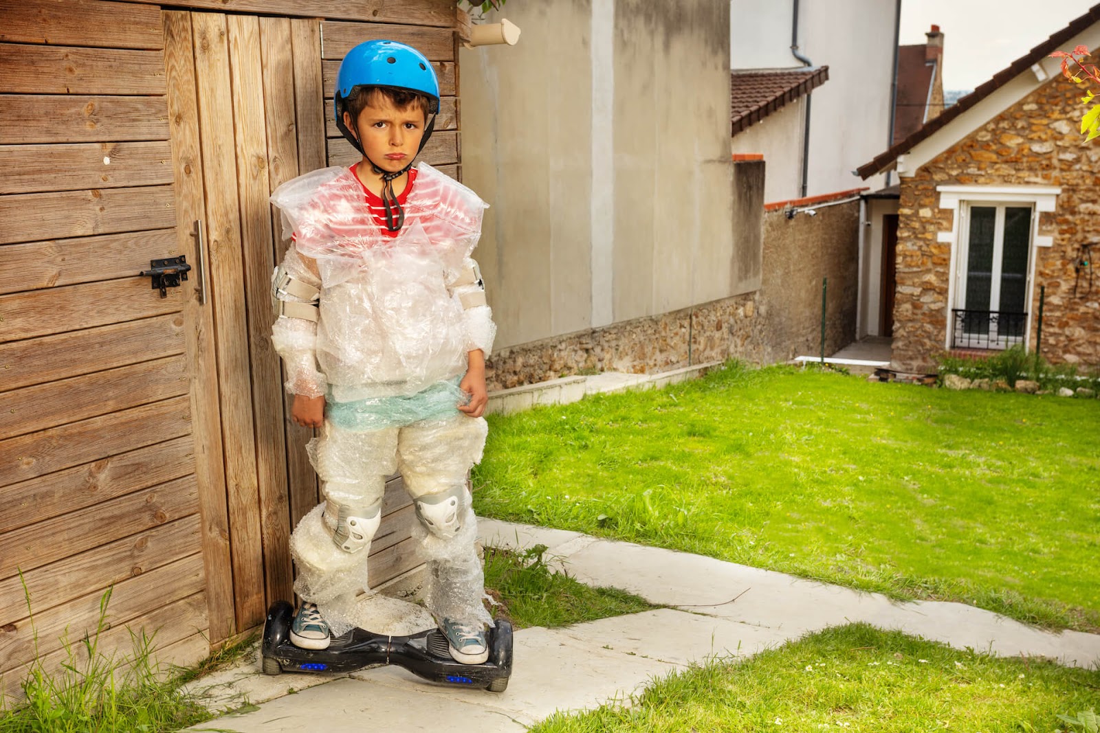 Boy trying to skateboard but covered in bubble wrap