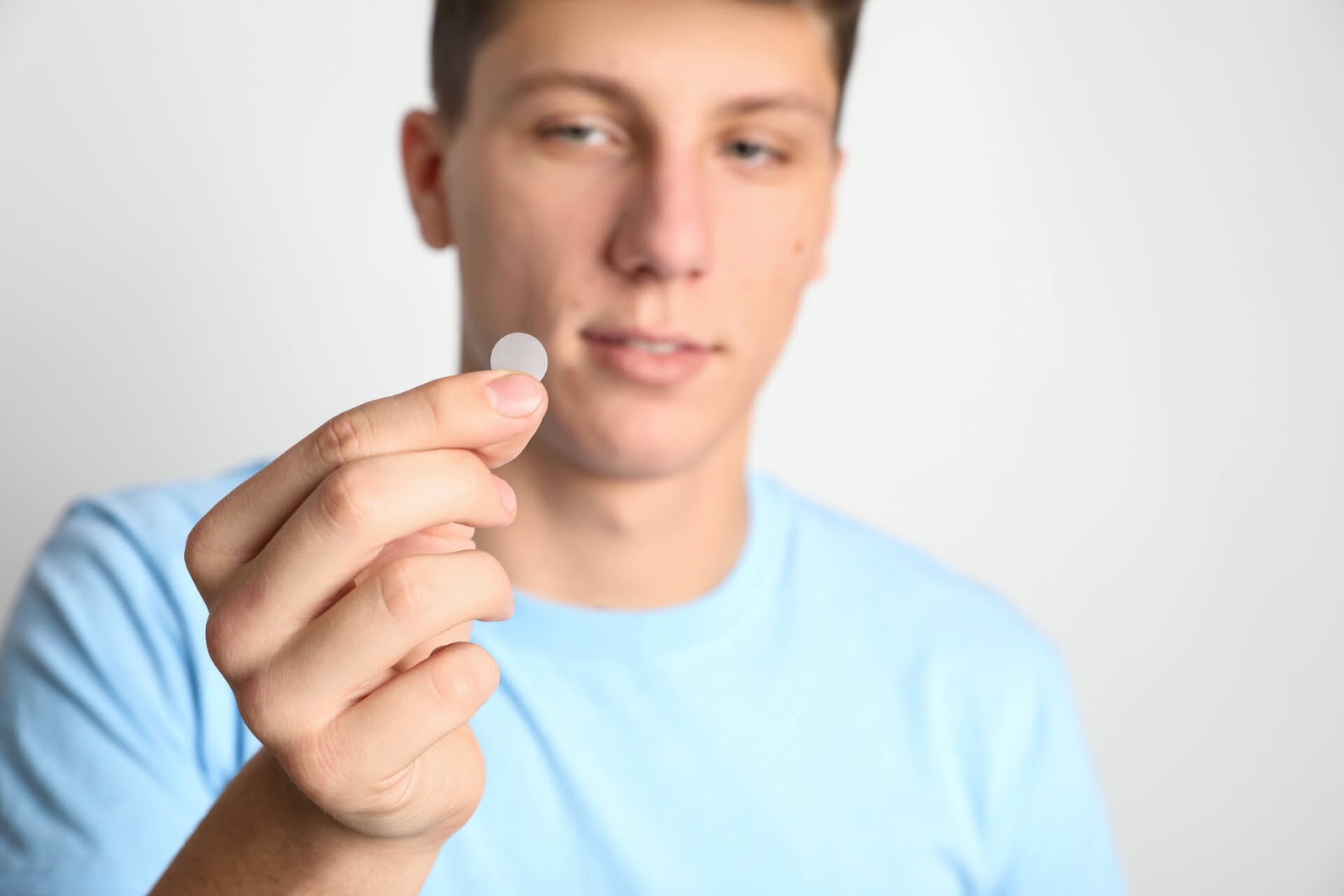 Teenage lad holding up an acne patch