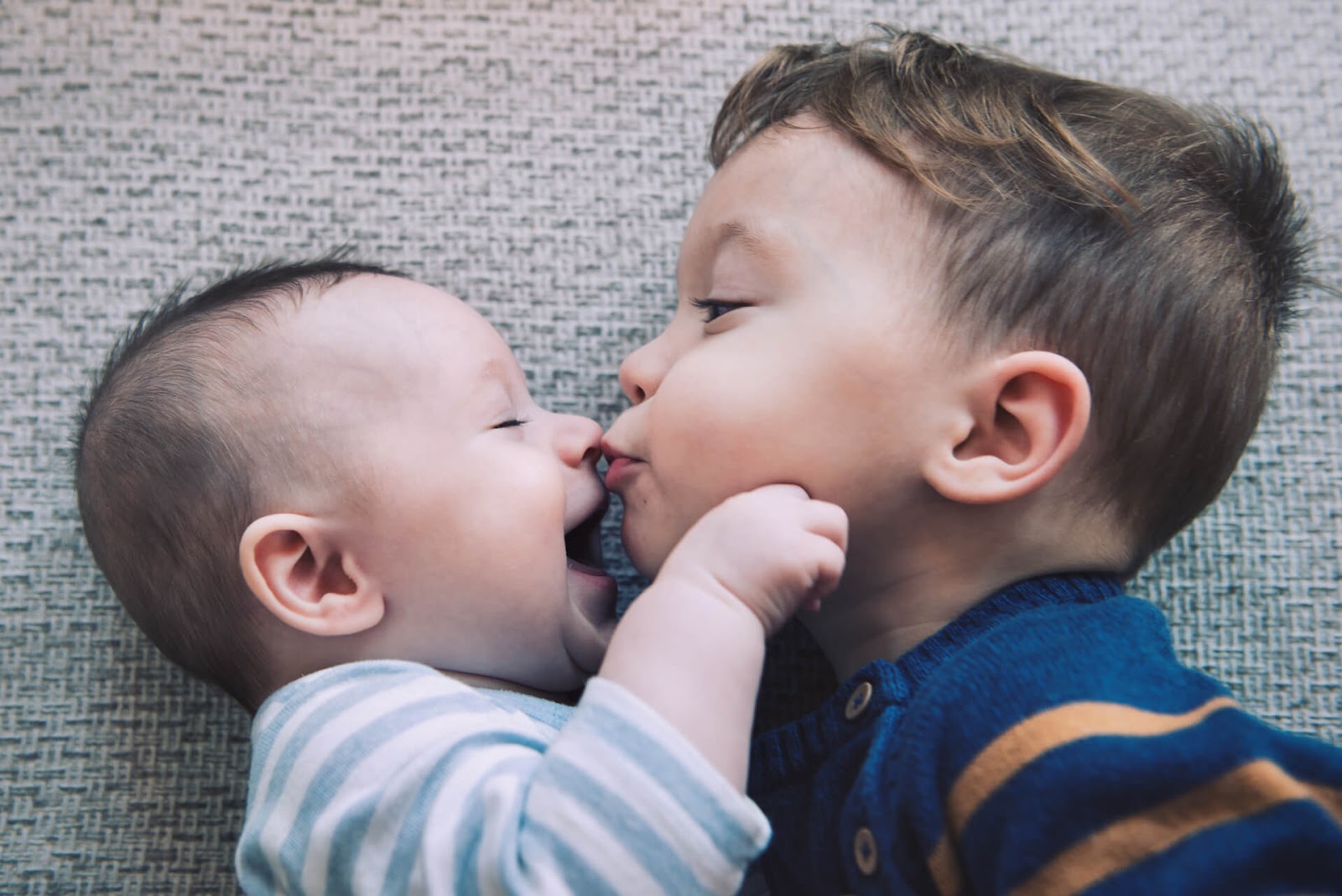 Young boy kissing his baby brother