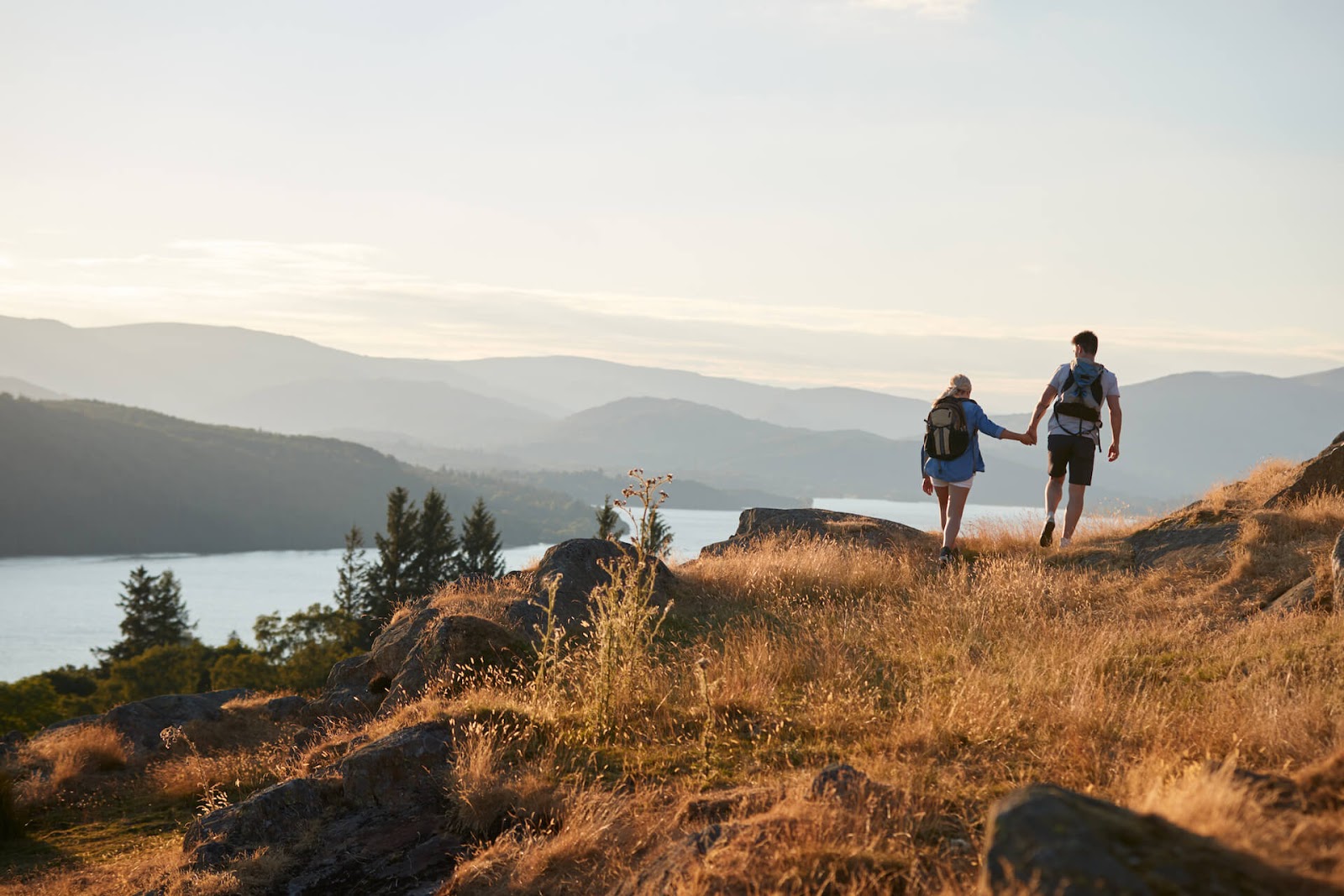 Man and woman holding hands as they hike