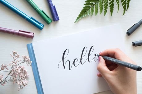 Woman writing hello on a paper