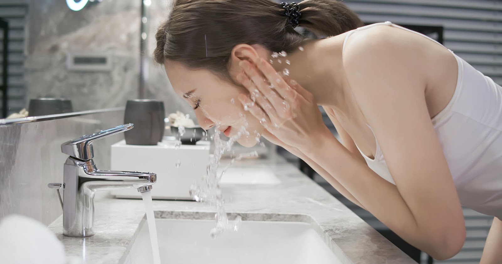 Woman splashing water on her face
