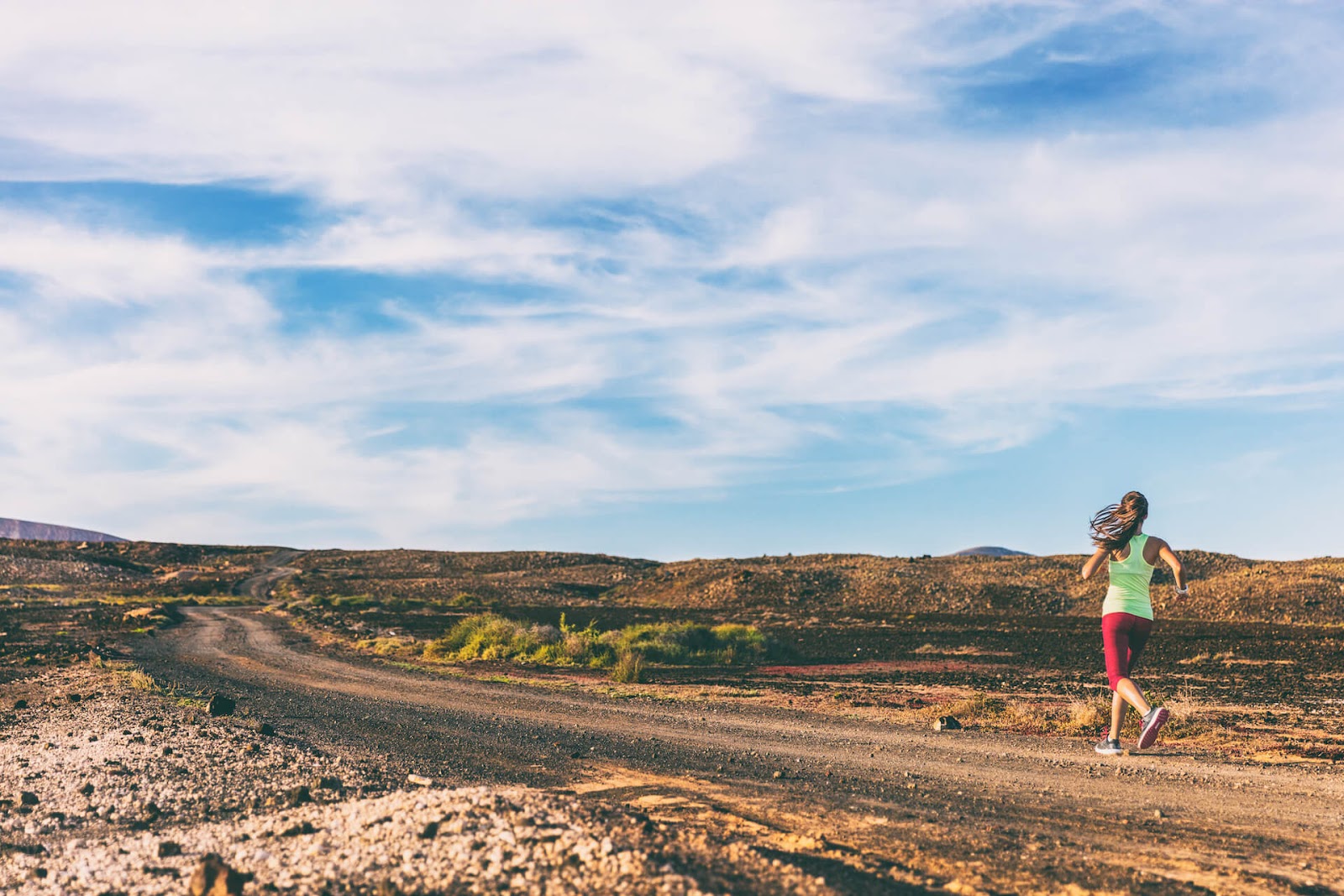 Woman jogging down a trail