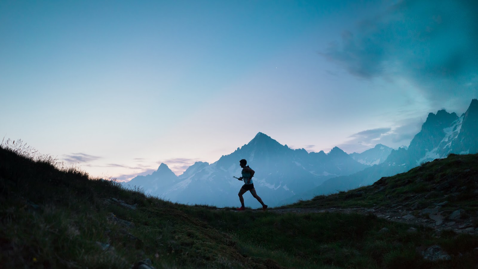 Man jogging on a trail with a mountain in the background