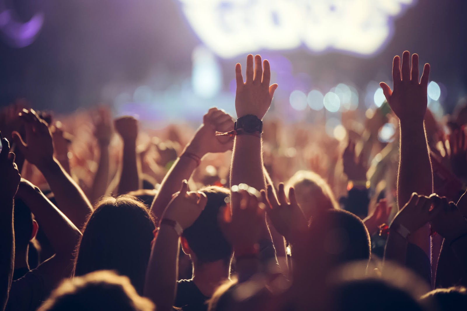 A crowd with their hands raised at a concert
