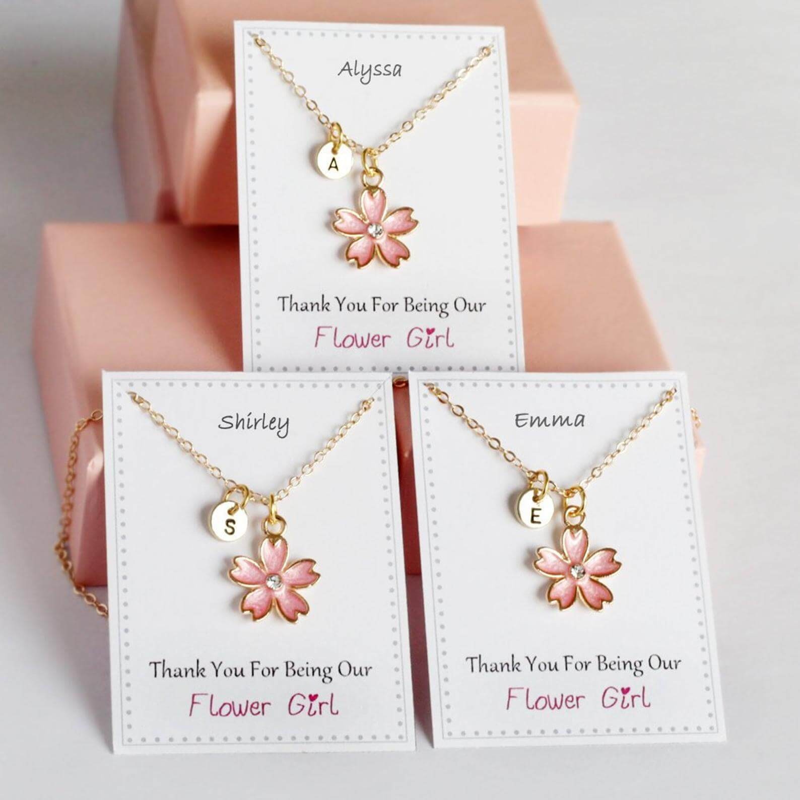 Toddler bracelet with a flower on a display that says "Thank you for being our flower girl"