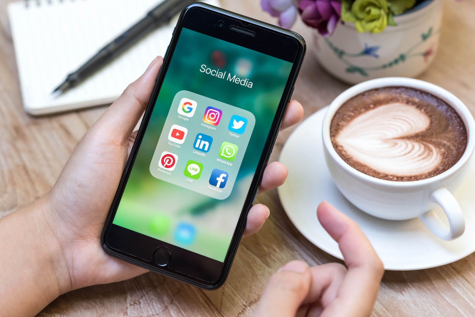 Woman looking at her social media apps with a coffee nearby