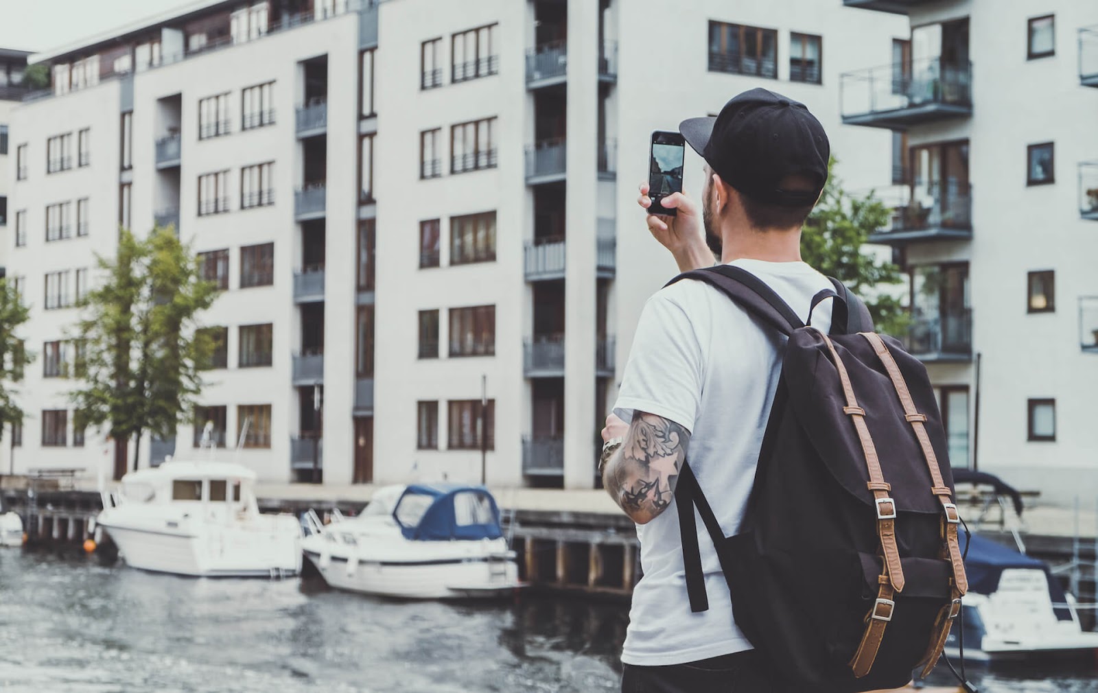 Man holding up phone to take a picture of some buildings