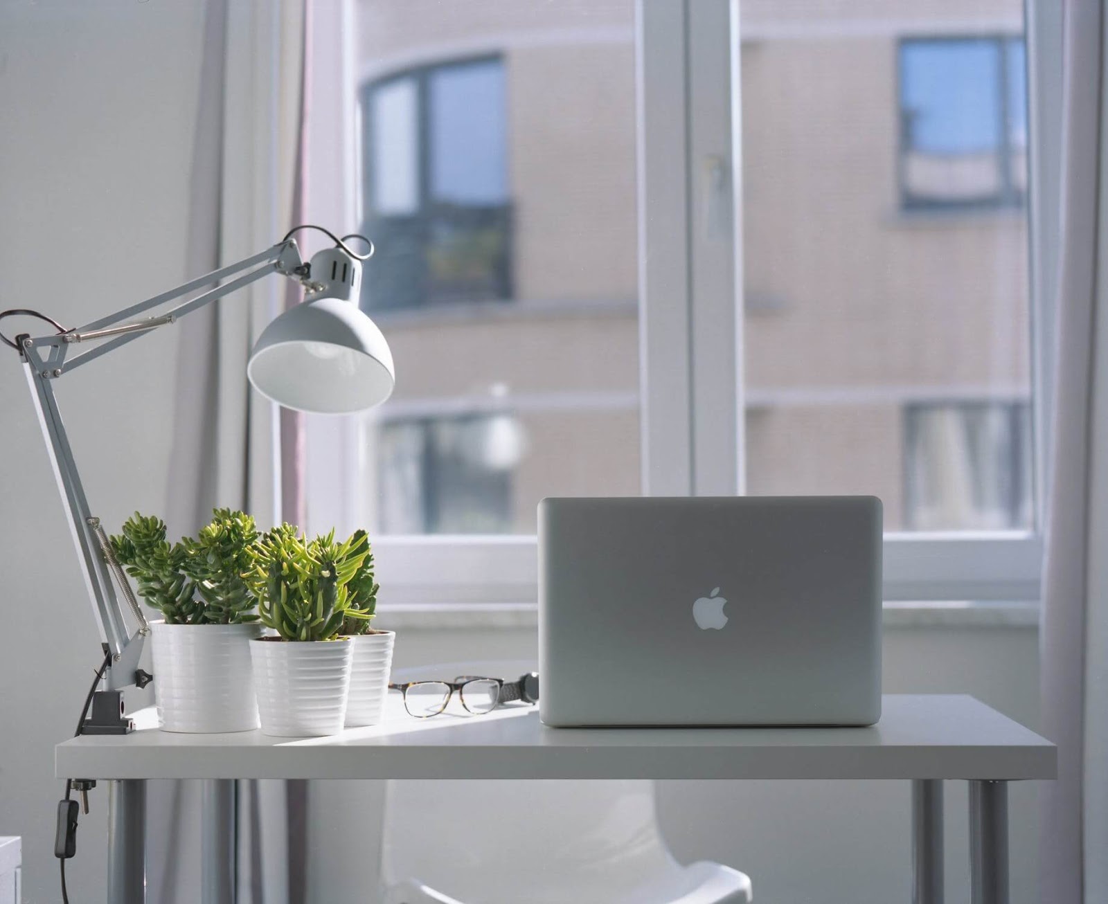 Serene desk with a macbook waiting for a college student to write a brilliant paper on it