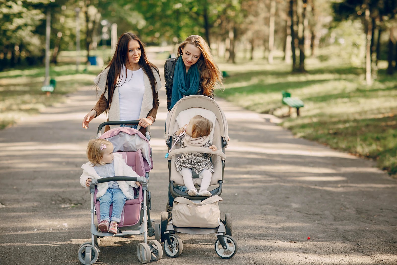 Two women pushing their strollers together