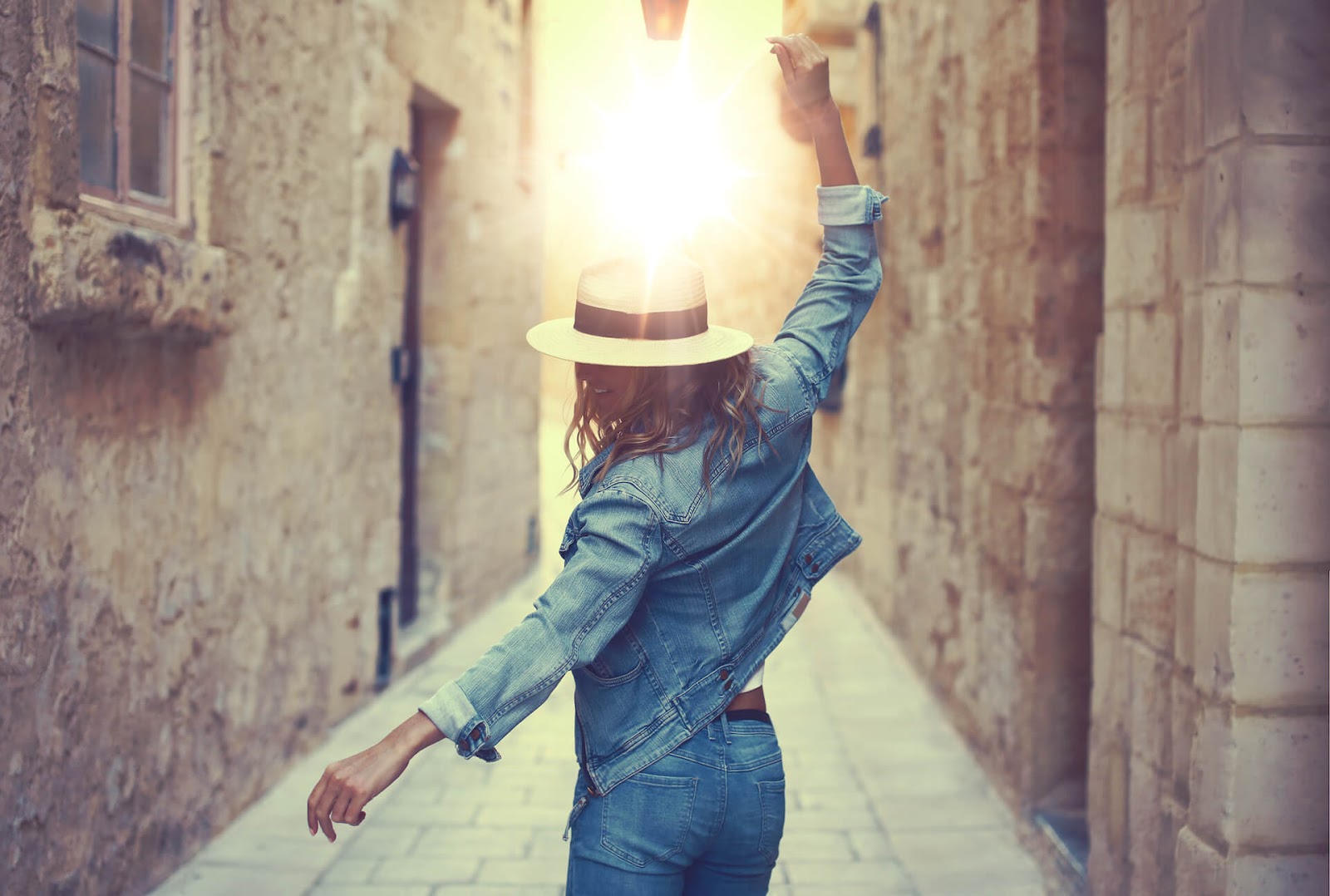 Woman dancing through a sun kissed alley