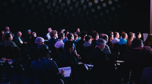 Several seated audience members at a presentation