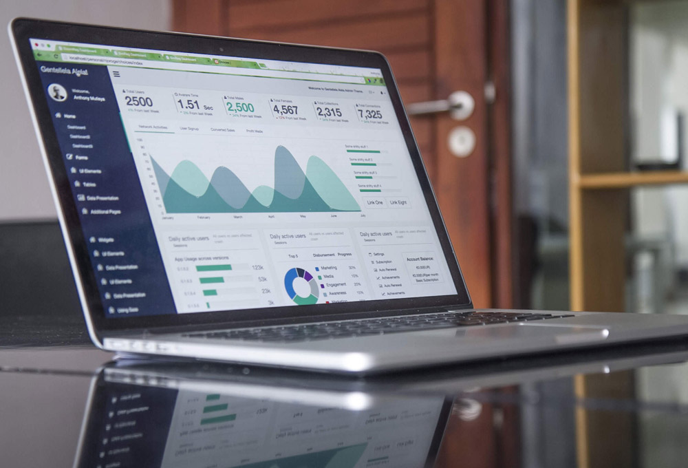A laptop on a desk showing graphs and charts