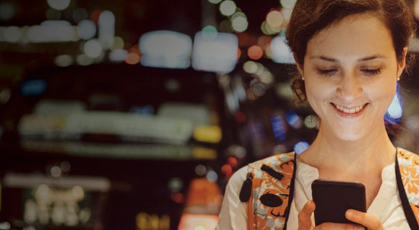 woman looking at a smartphone and smiling