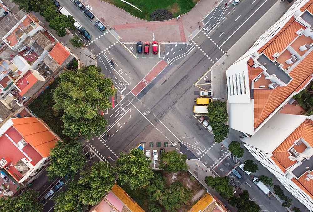 Aerial view of street intersection with brown and orange roofed buildings on the sides