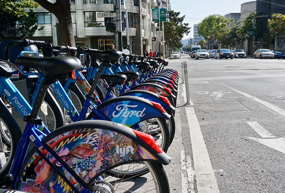 Bikeshare bikes parked in bike rack on side of city street