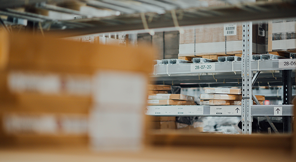 Cardboard boxes in front of a shelf in a warehouse