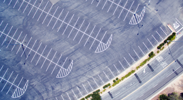 Aerial view of empty parking lot next to road