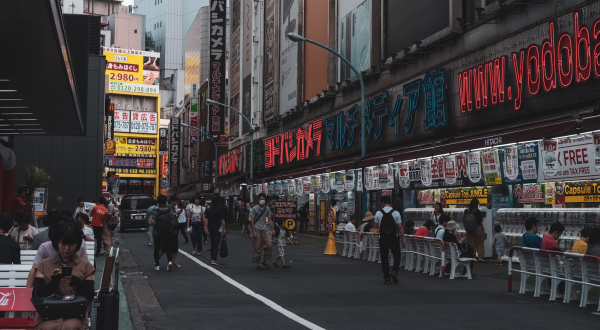 People walking and sitting on city street in Tokyo