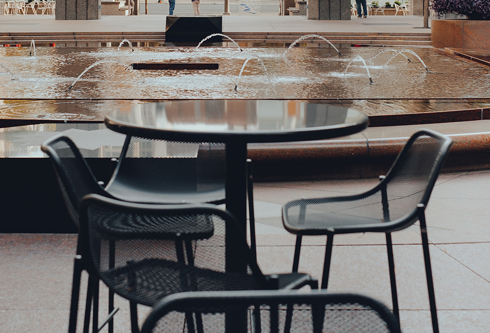 Table and chairs in front of fountain