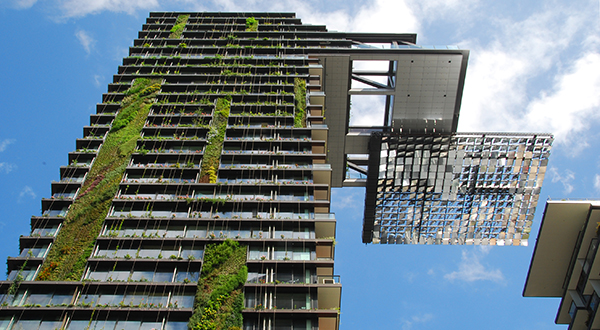 Skyscraper with plant strips on its side with solar mirror