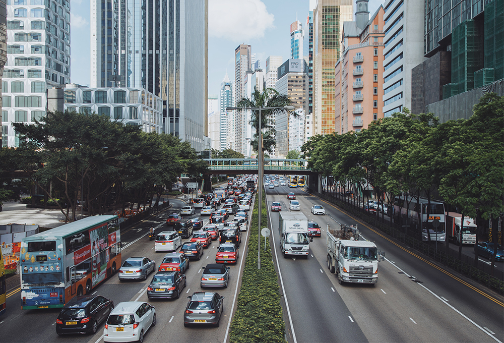 busy street in Hong Kong lined with trees and buildings