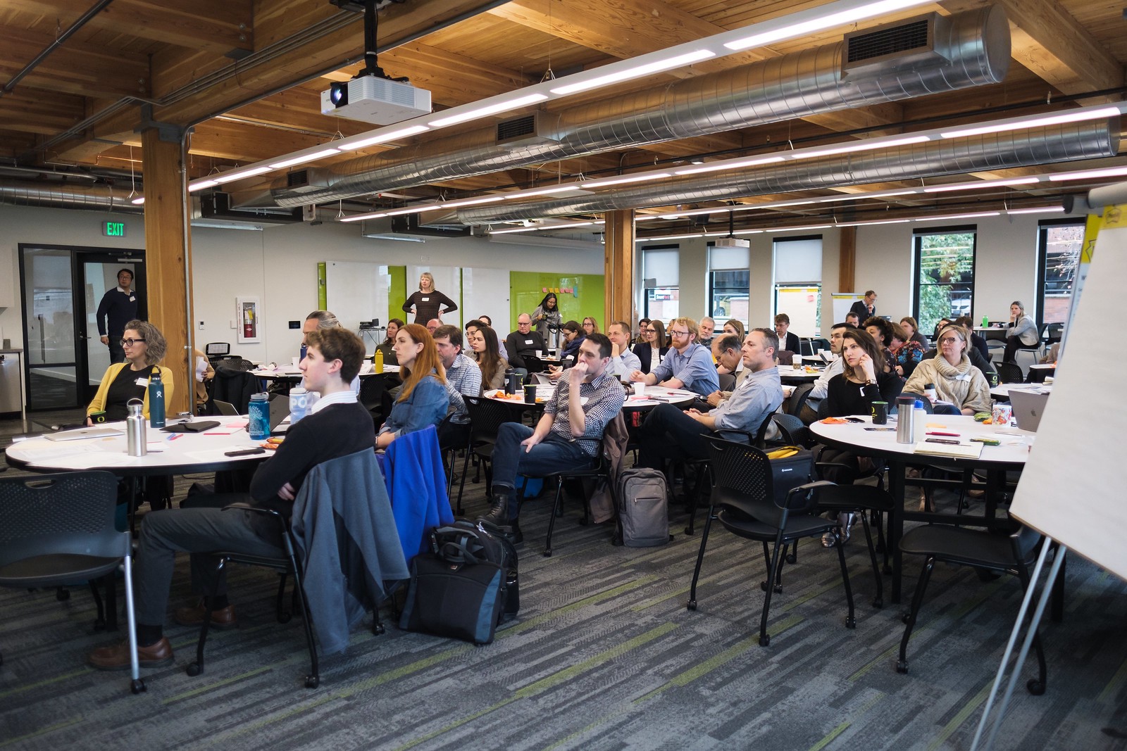 Large conference room full of round tables and people