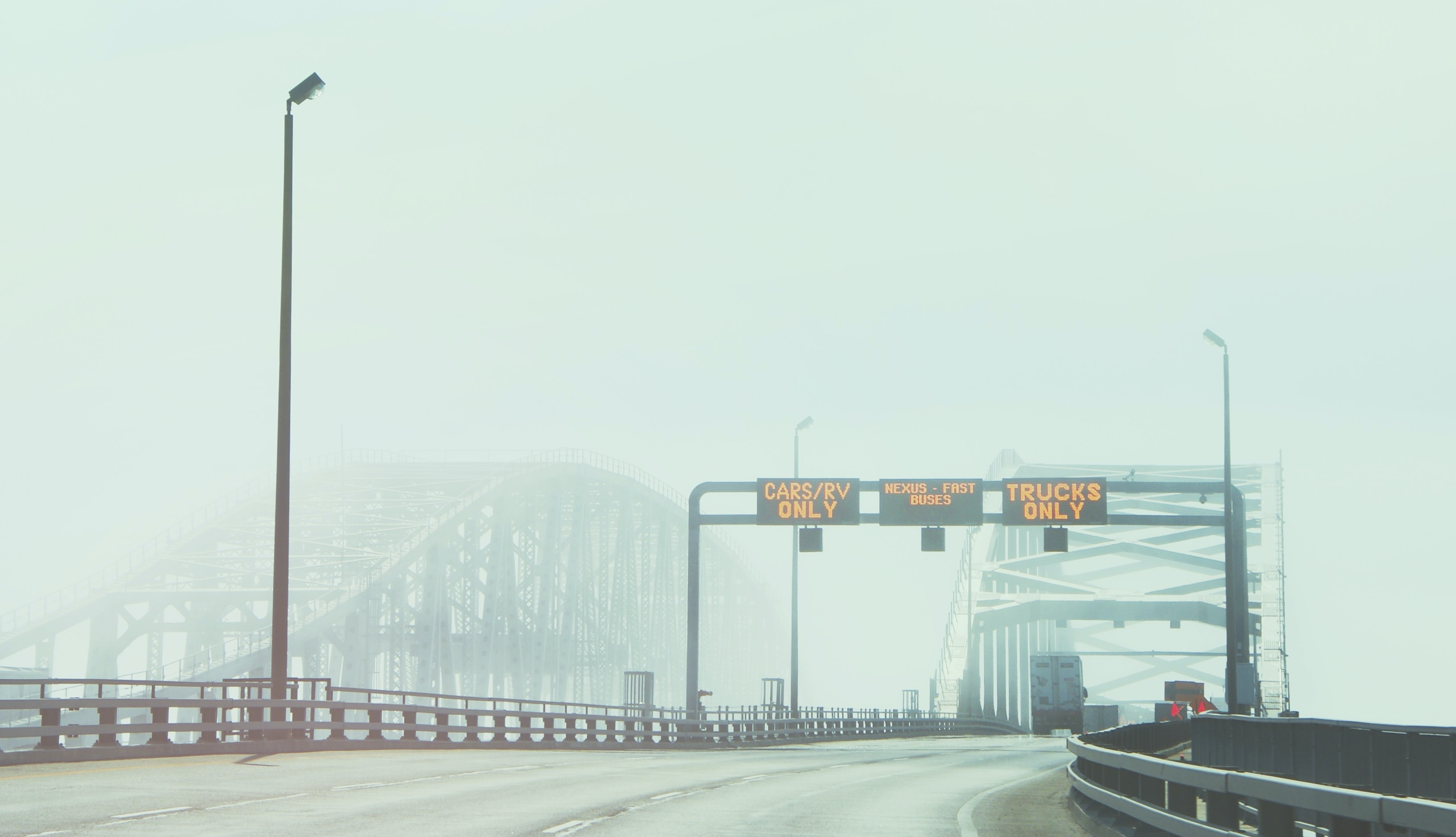 Toll bridge with signs indicating which lane different types of vehicles should use. 