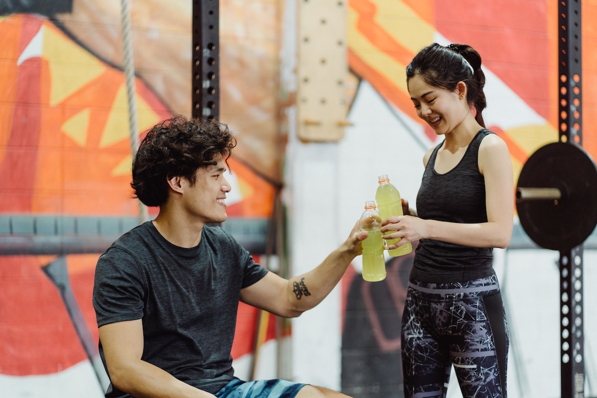 2 athletes hydrating in the gym